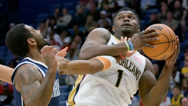 Dallas Mavs' Kyrie Irving attempts to steal the ball from New Orleans Pelcians' Zion Williamson.